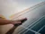 A hand touching solar panel